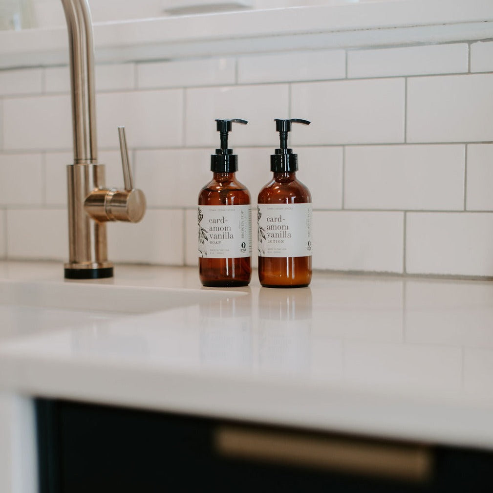 Cardamom Vanilla 8oz lotion kitchen counter next to Cardamom Vanilla liquid soap
