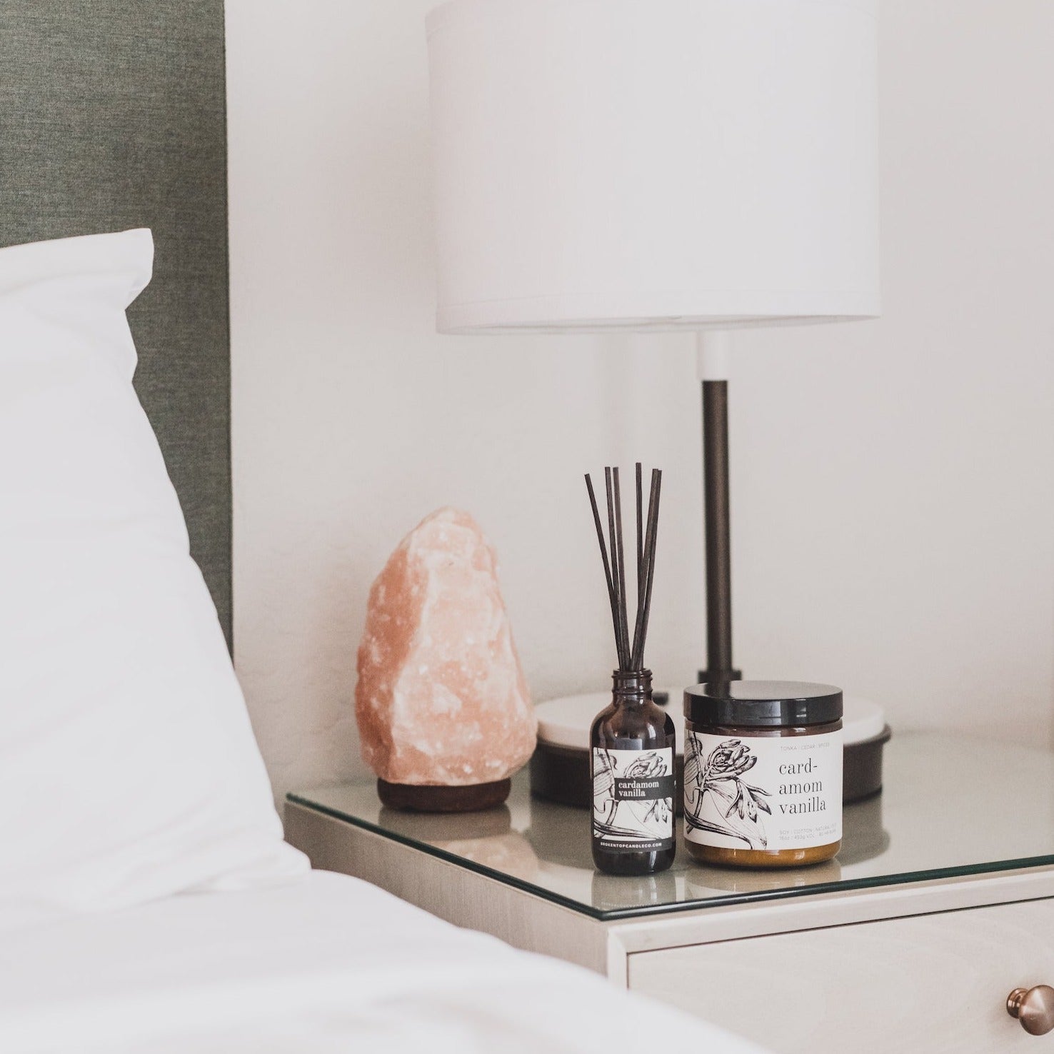 Cardamom Vanilla Reed diffuser and box on side table next to Cardamom Vanilla candle