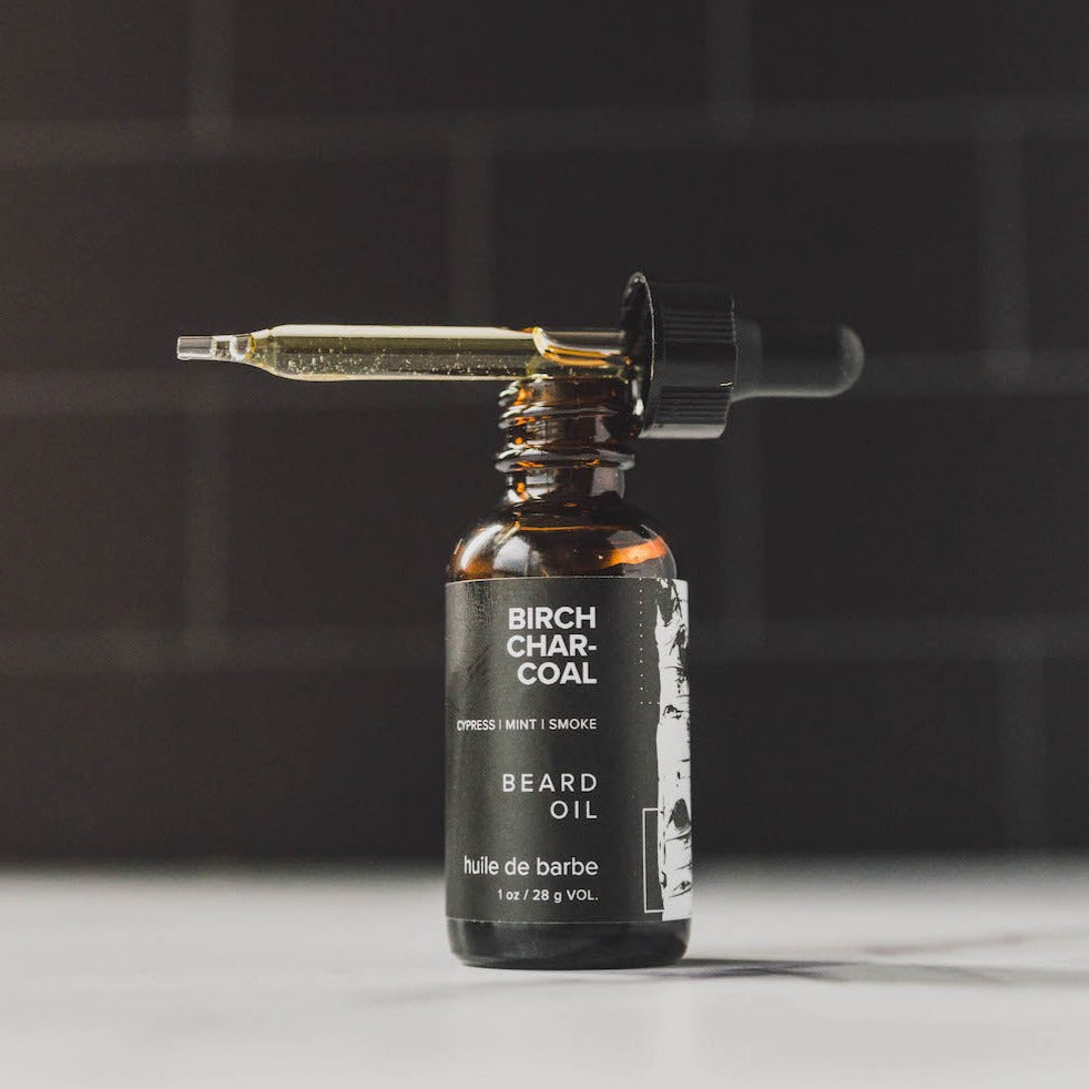 Birch Charcoal beard oil on counter with dropper