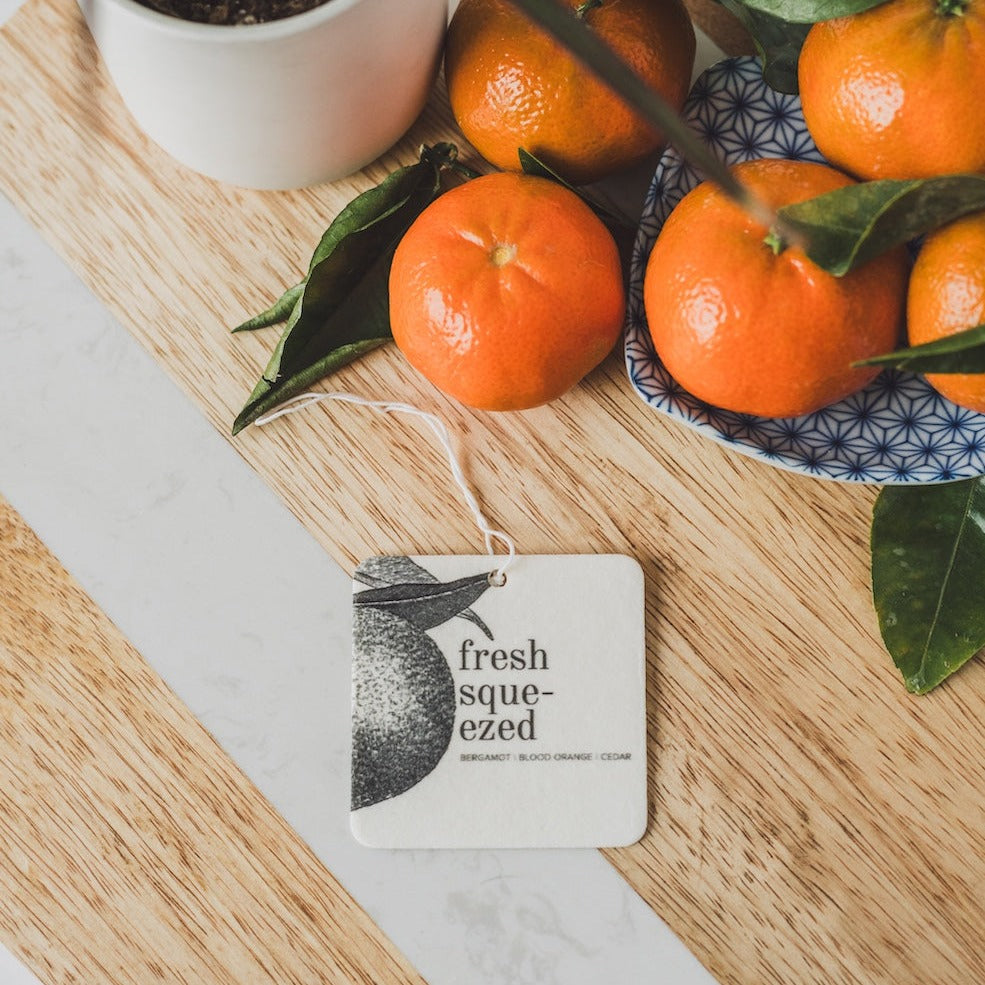 Fresh Squeezed Car Freshener next to tangerines.