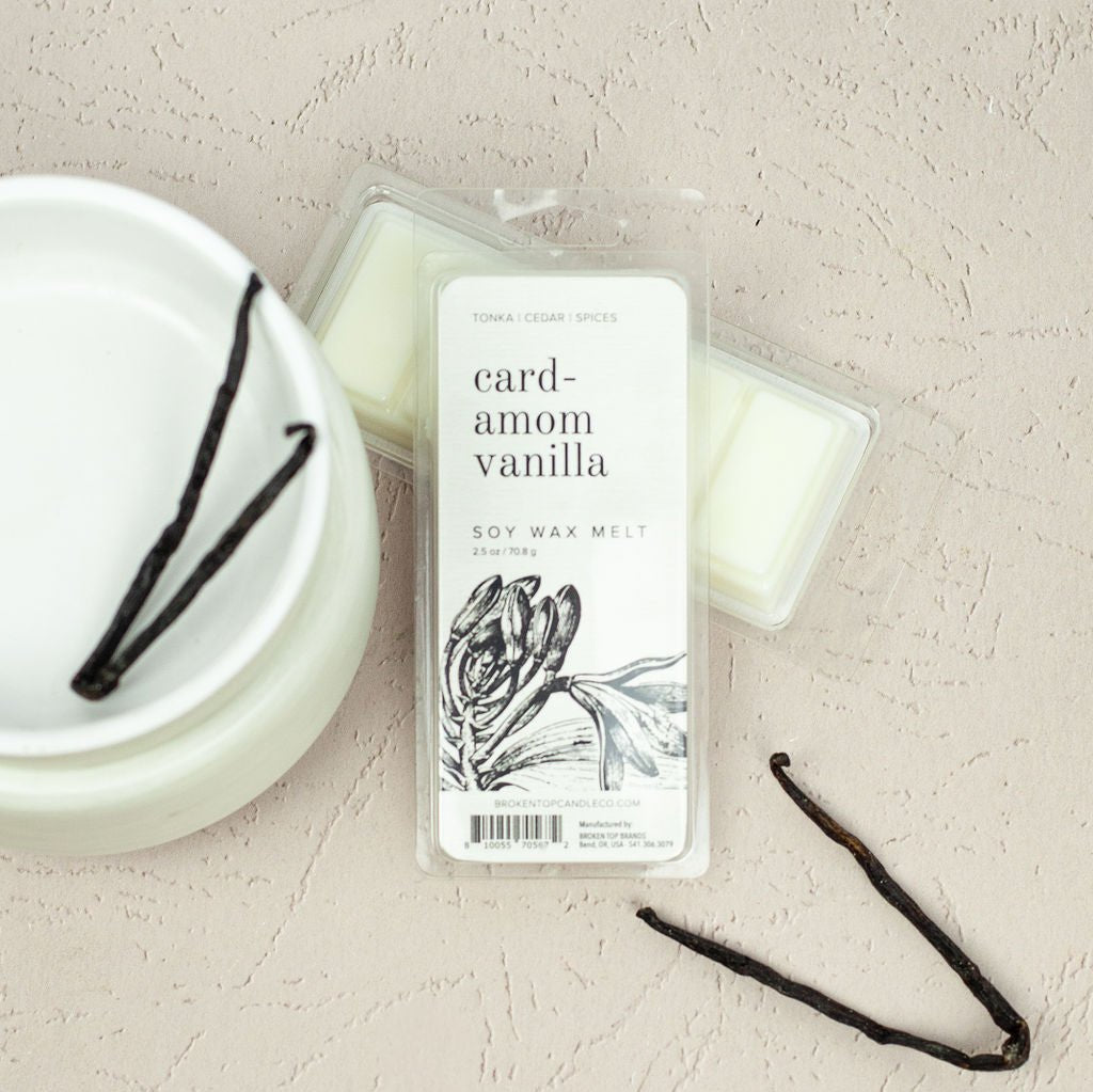 Cardamom Vanilla 2.5oz wax melts on beige table next to wax melter and vanilla