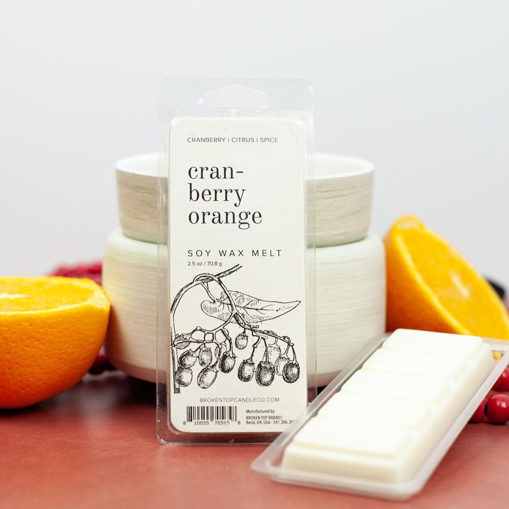 Cranberry Orange Wax Melts infront of white wax warmer next to citrus.