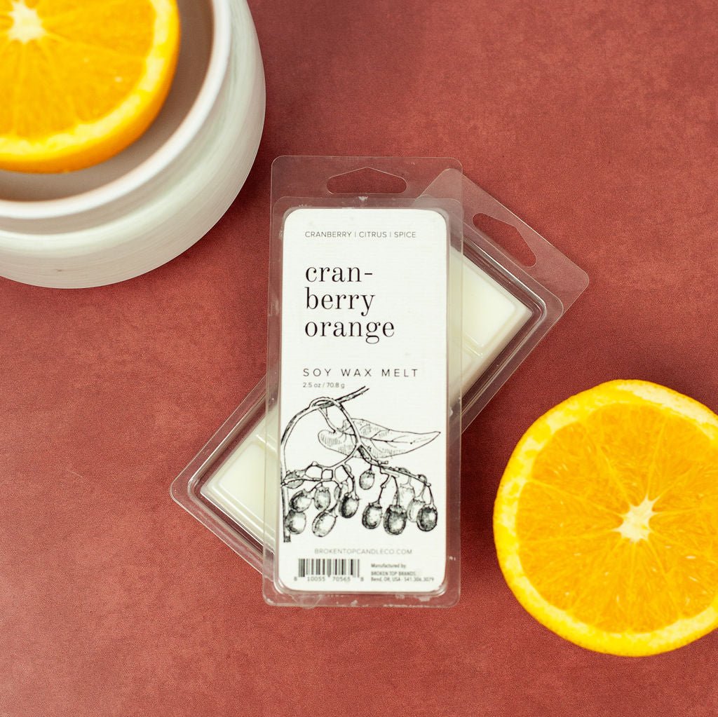 Cranberry Orange 2.5oz wax melts on red table next to citrus