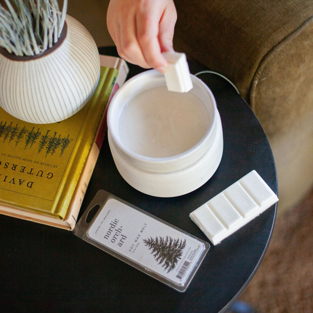 Nordic Orchard Wax Melt being placed in a white wax warmer.