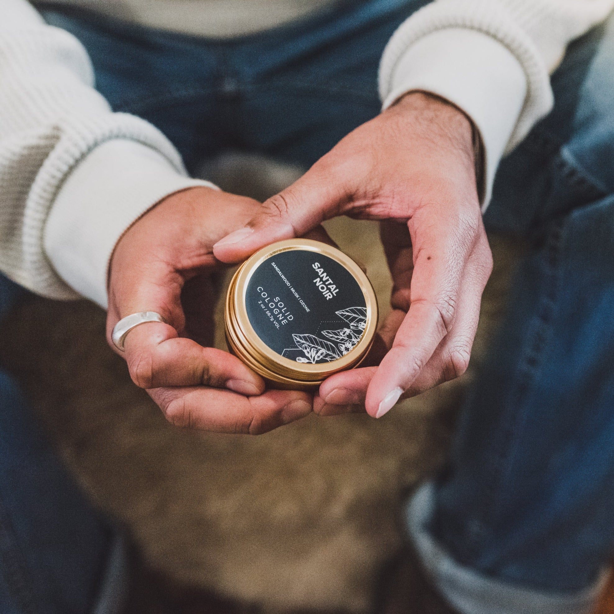 Santal Noir solid cologne being held by gentleman