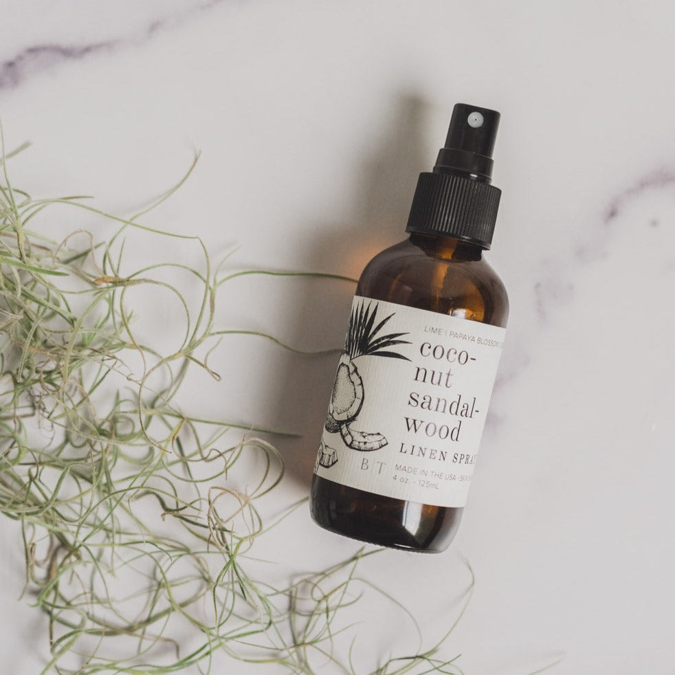 4oz Coconut Sandalwood linen spray on white table