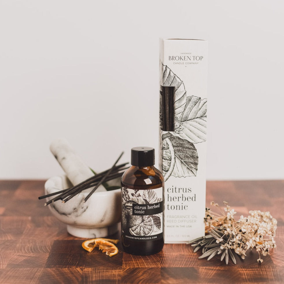 Citrus Herbed Tonic Reed diffuser and box on wood table and dried decor