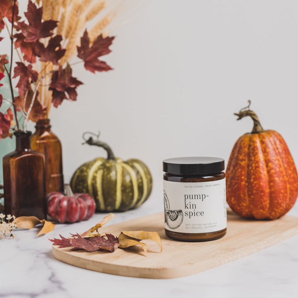 9oz Pumpkin Spice candle on wood cutting board and pumpkins