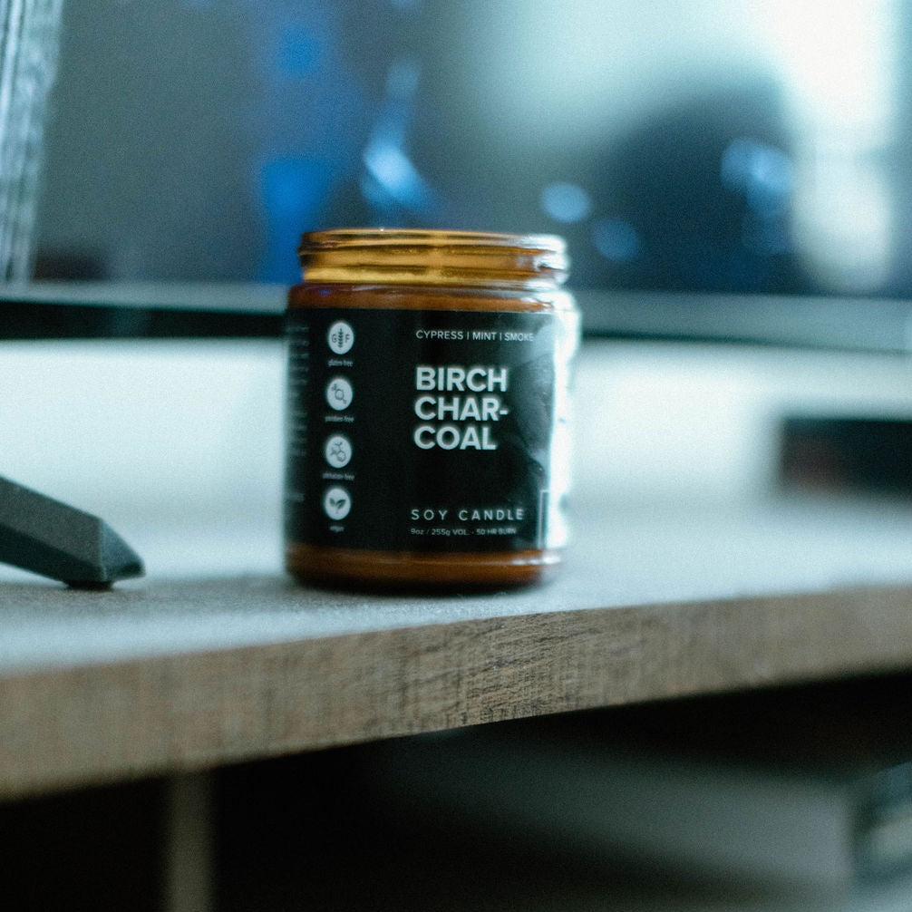 9oz Birch Charcoal candle a wooden shelf