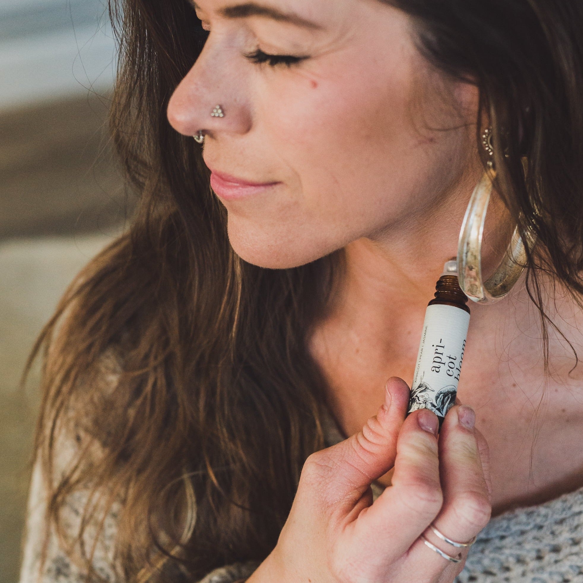 Apricot Bloom roll-on perfume being held and applied by women