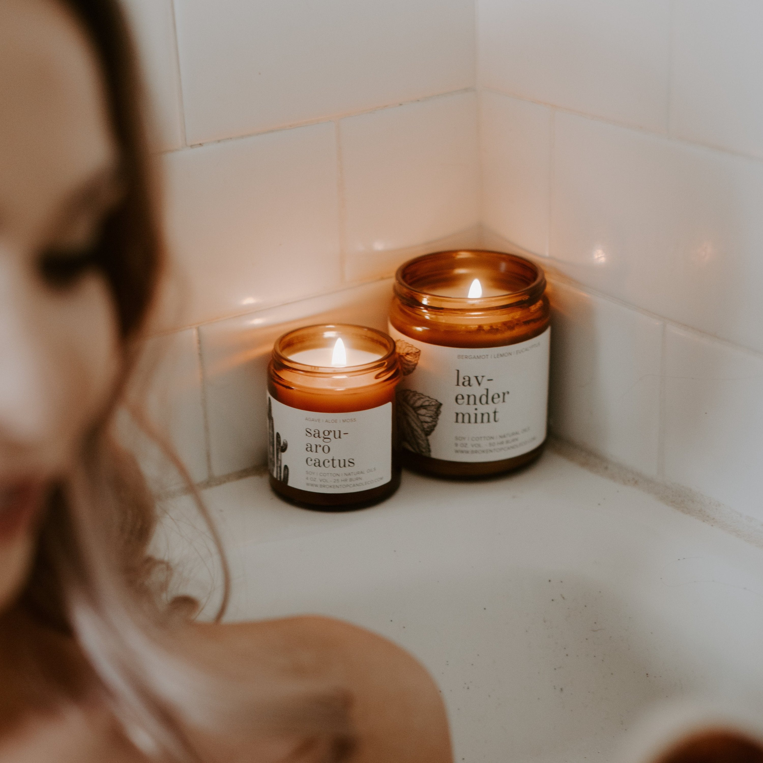 9oz Lavender Mint candles next to bath and women