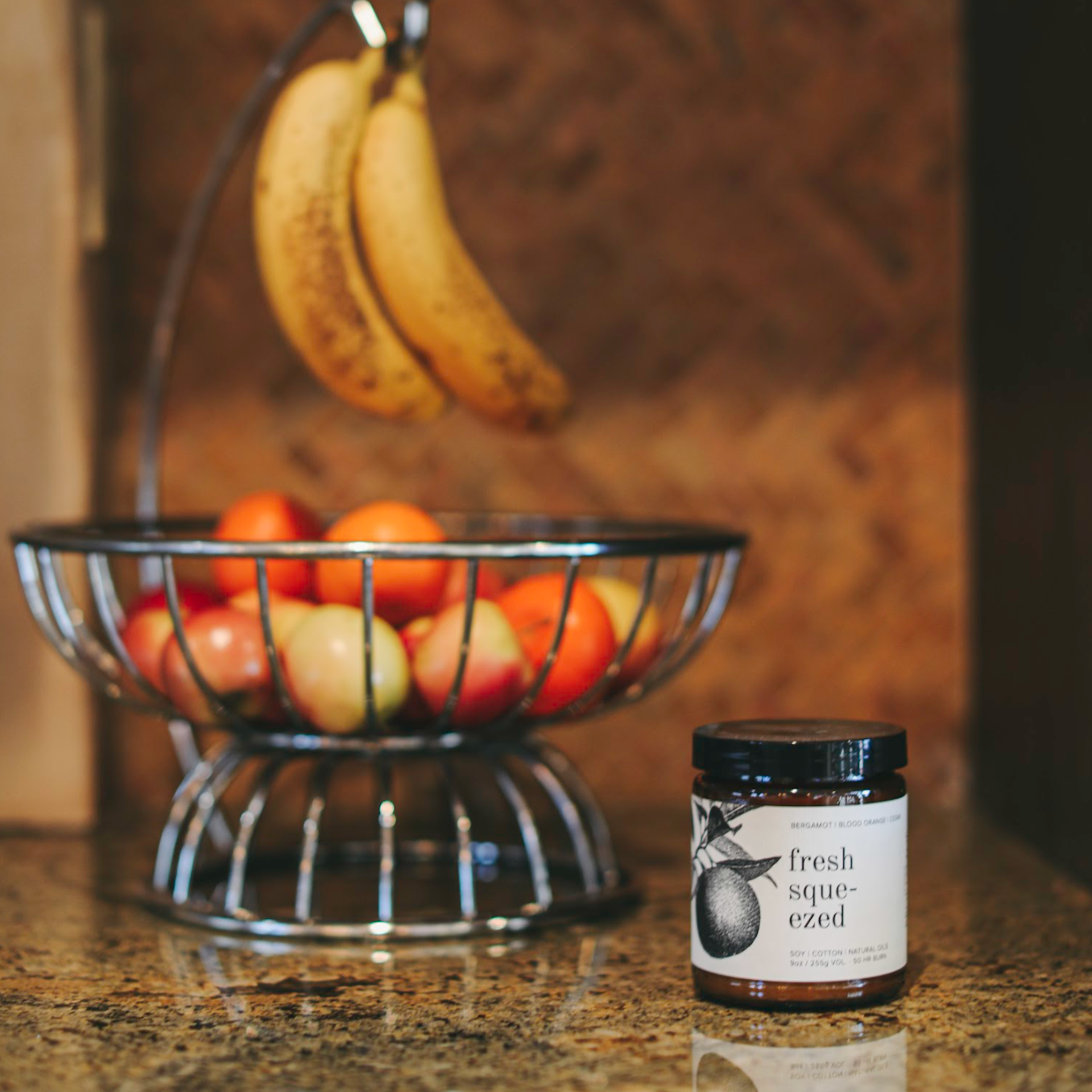 9oz Fresh Squeezed candle on counter next to fruit bowl
