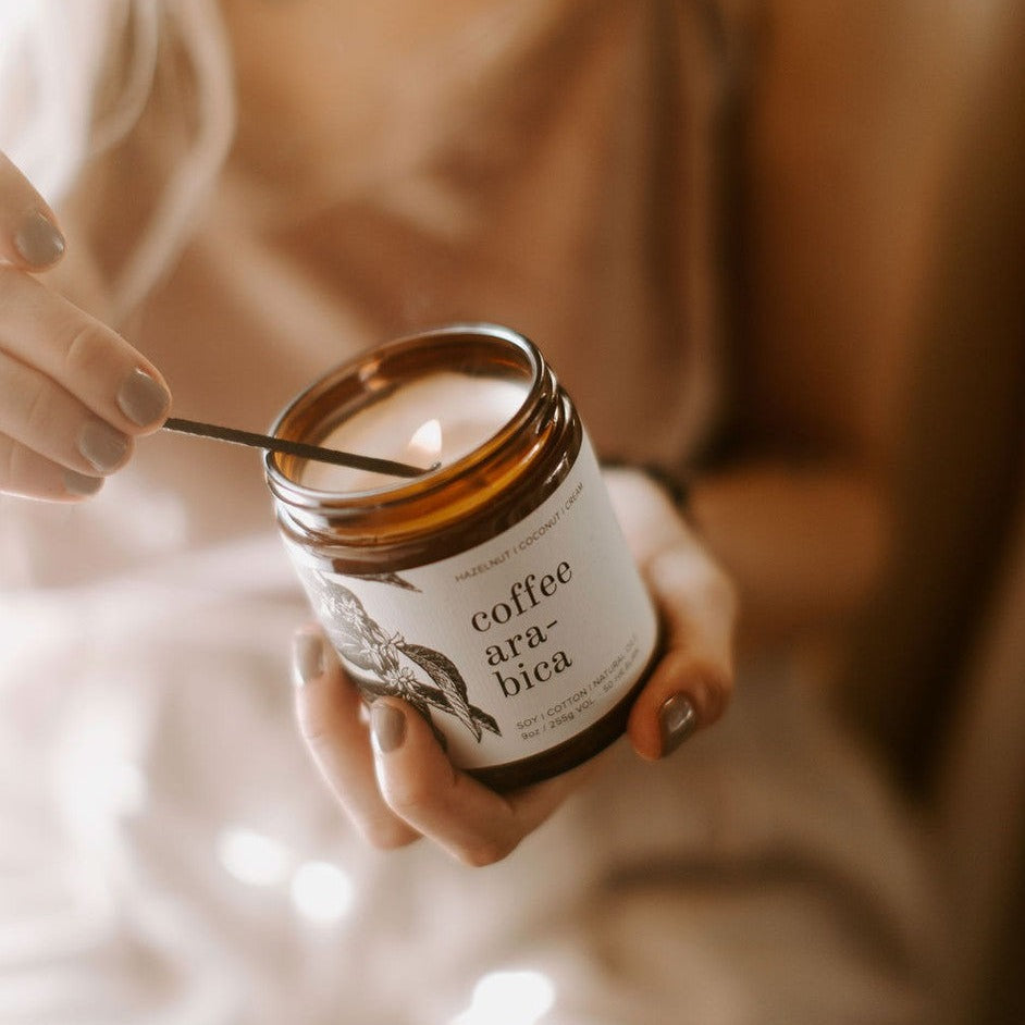 9oz Coffee Arabica candle being held and lit in women's hand