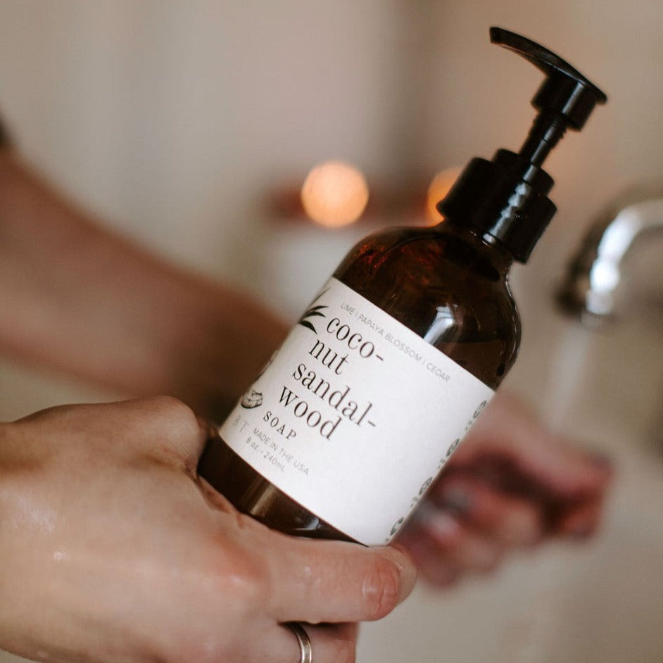 Coconut Sandalwood 8oz liquid soap held in women's hand