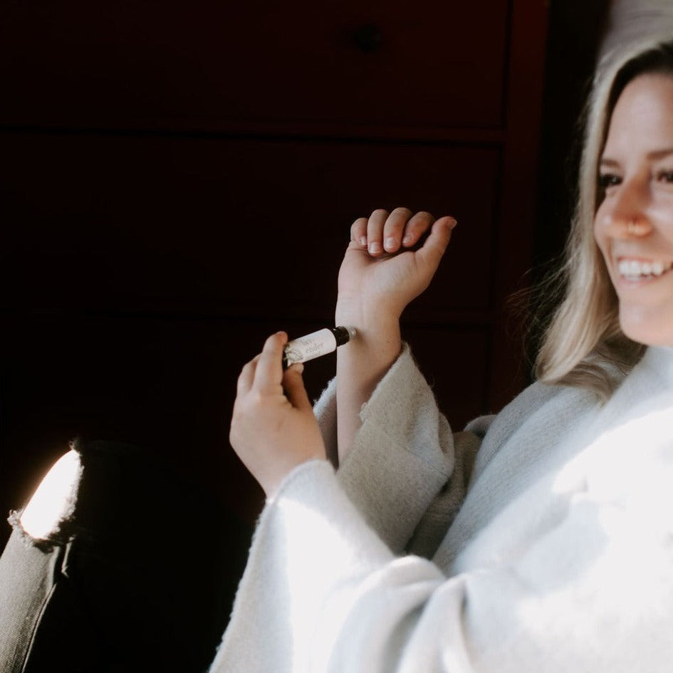 Lavender Mint roll-on perfume beind help and applied by smiling women