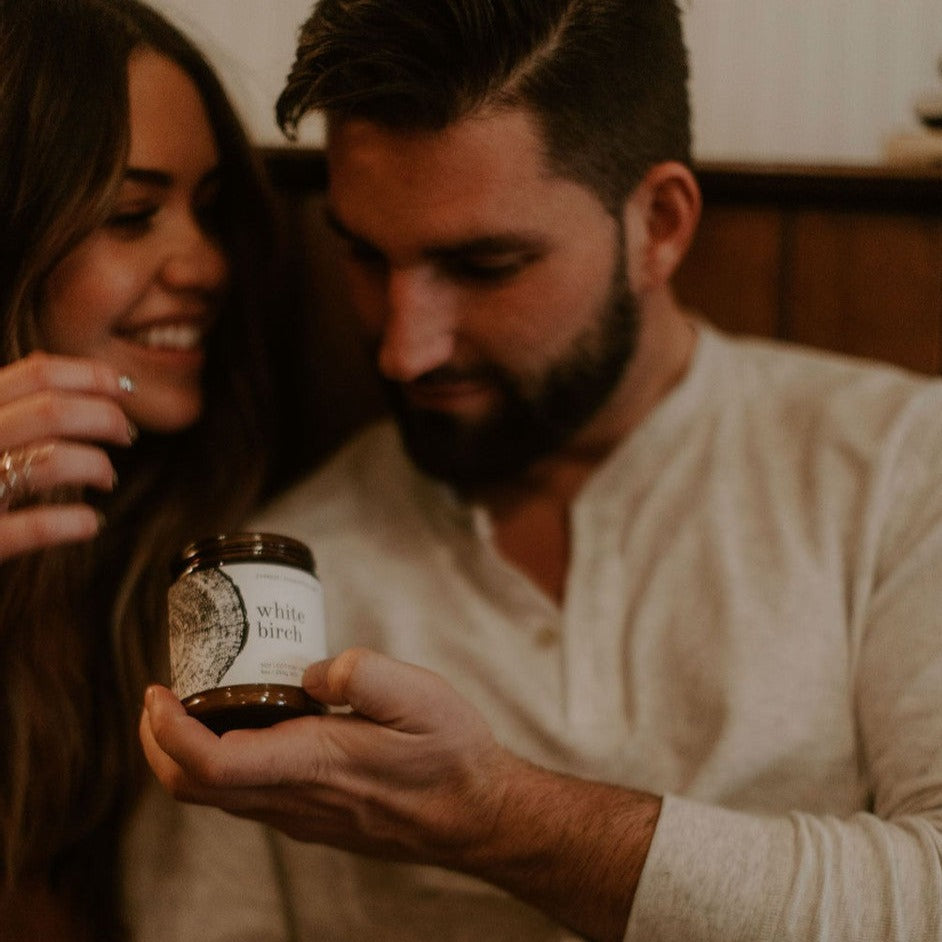 9oz White Birch candle being held by man and laughing women