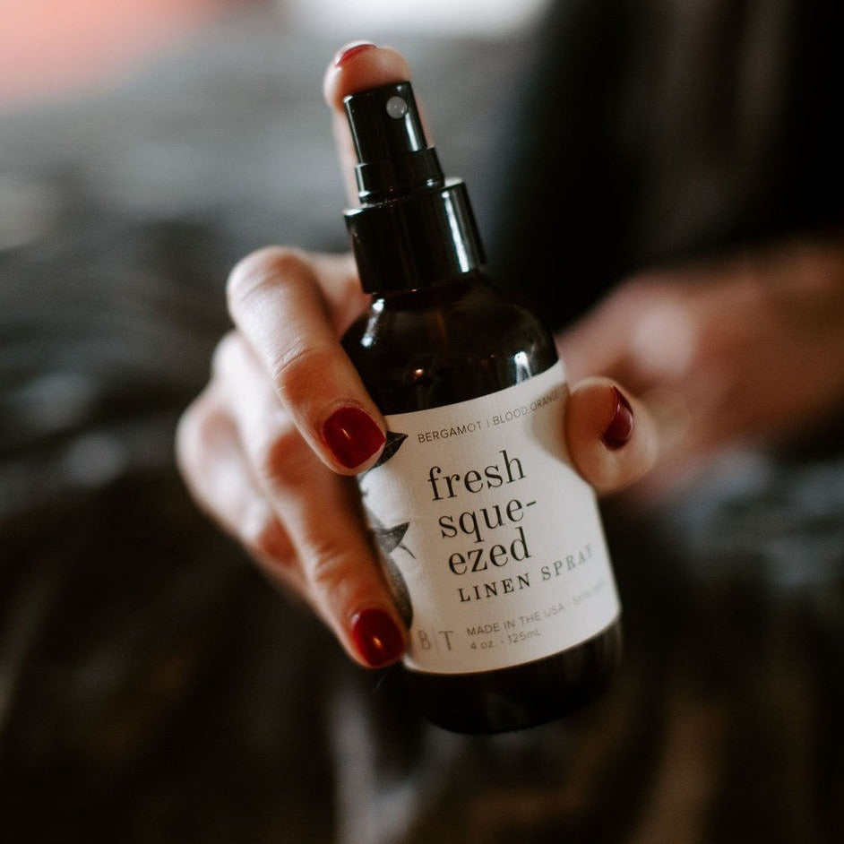 4oz Fresh Squeezed linen spray be held by women's hand