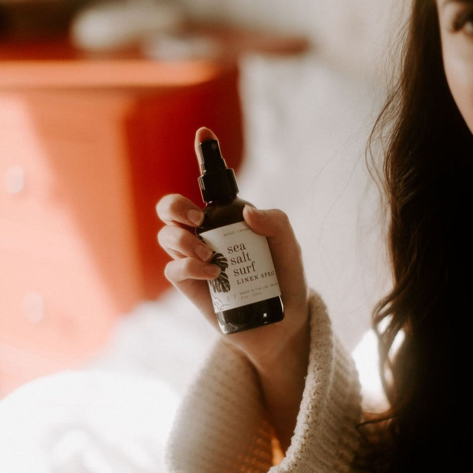 4oz Sea Salt Surf spray on white being held by women