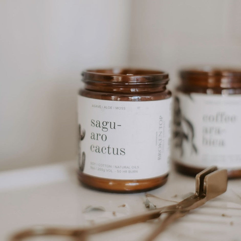 9oz Saguaro Cactus candle on table next to Coffee Arabica 9oz candle and snuffer