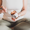 4oz Tumalo Cider candle being held by women and lit by wood match