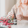 Cranberry Orange Reed diffuser on table near holiday decor