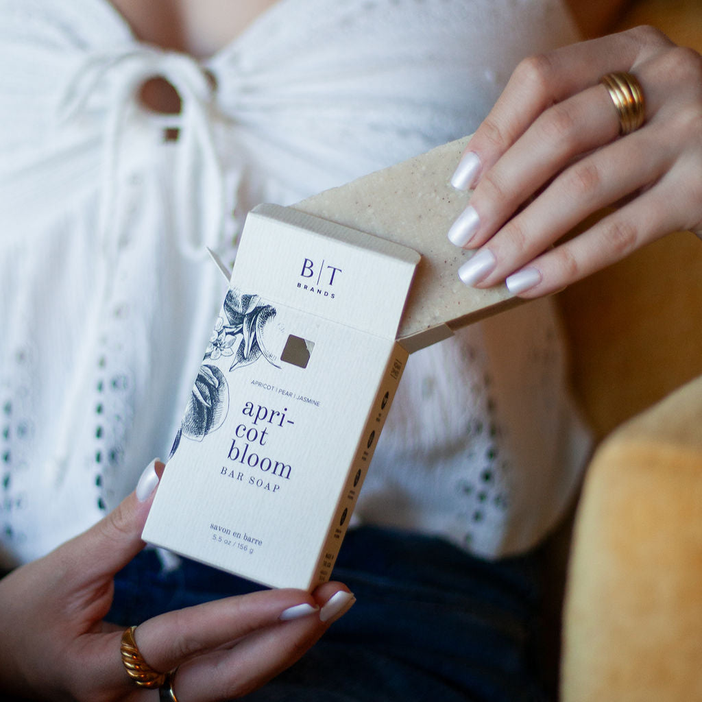 Apricot Bloom Bar Soap being unboxed by woman's hands. 