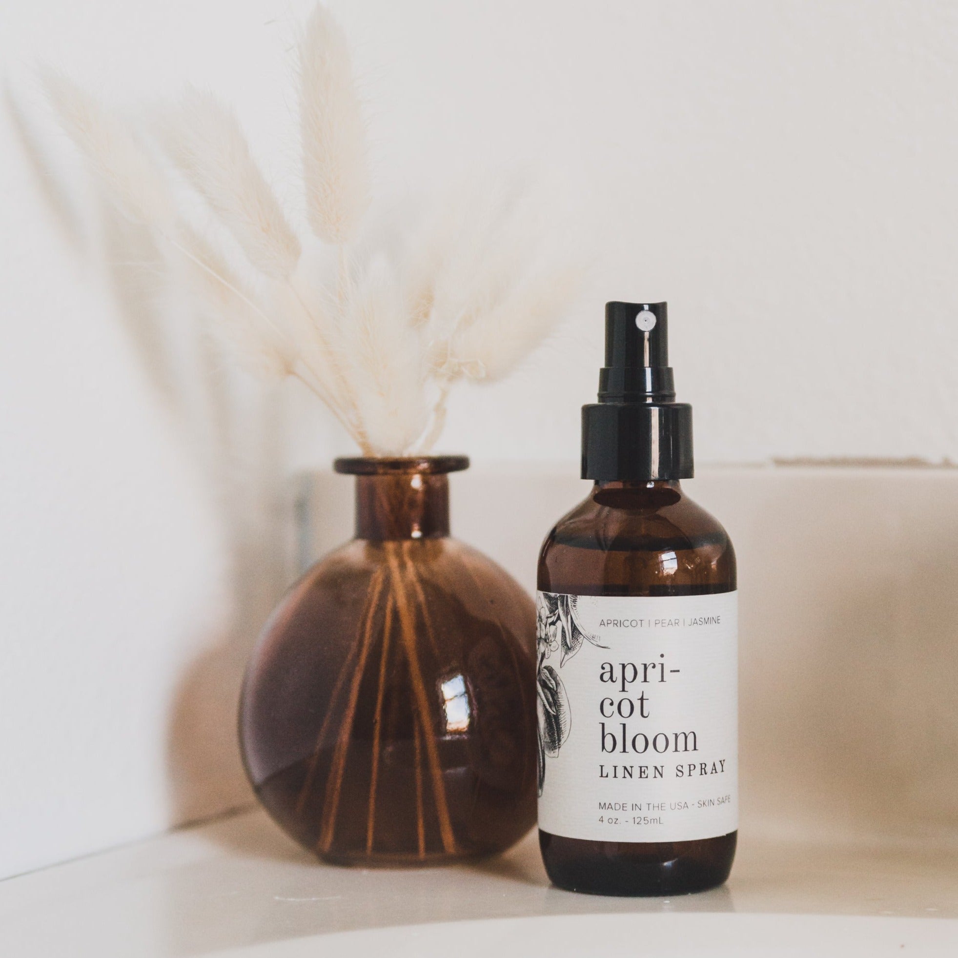 4oz Apricot Bloom linen spray next to vase