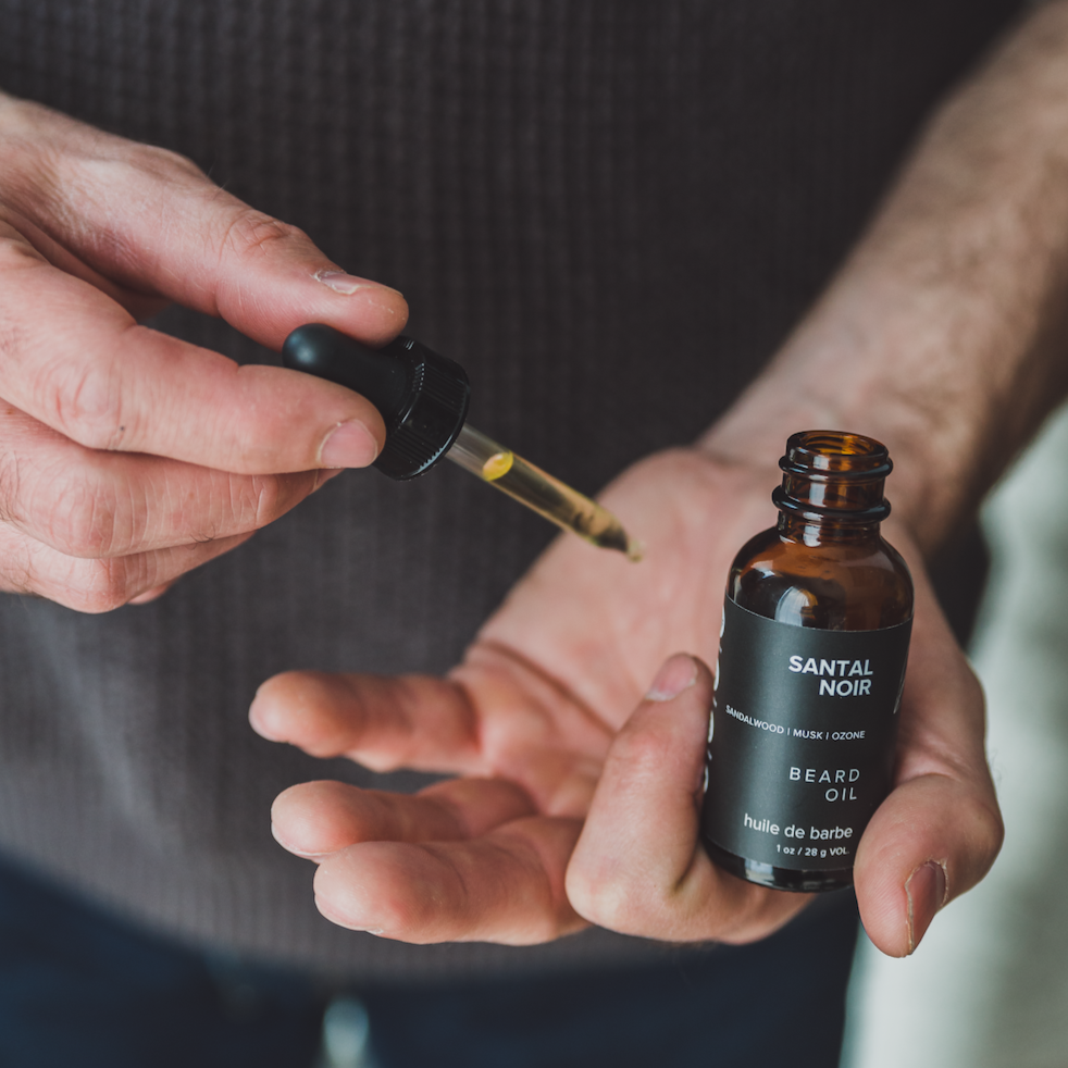 Black Coral Tide beard oil and dropper with man's hands