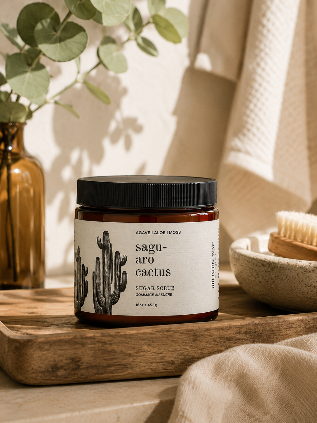 16oz Saguaro Cactus Sugar Scrub on counter with  plant in background