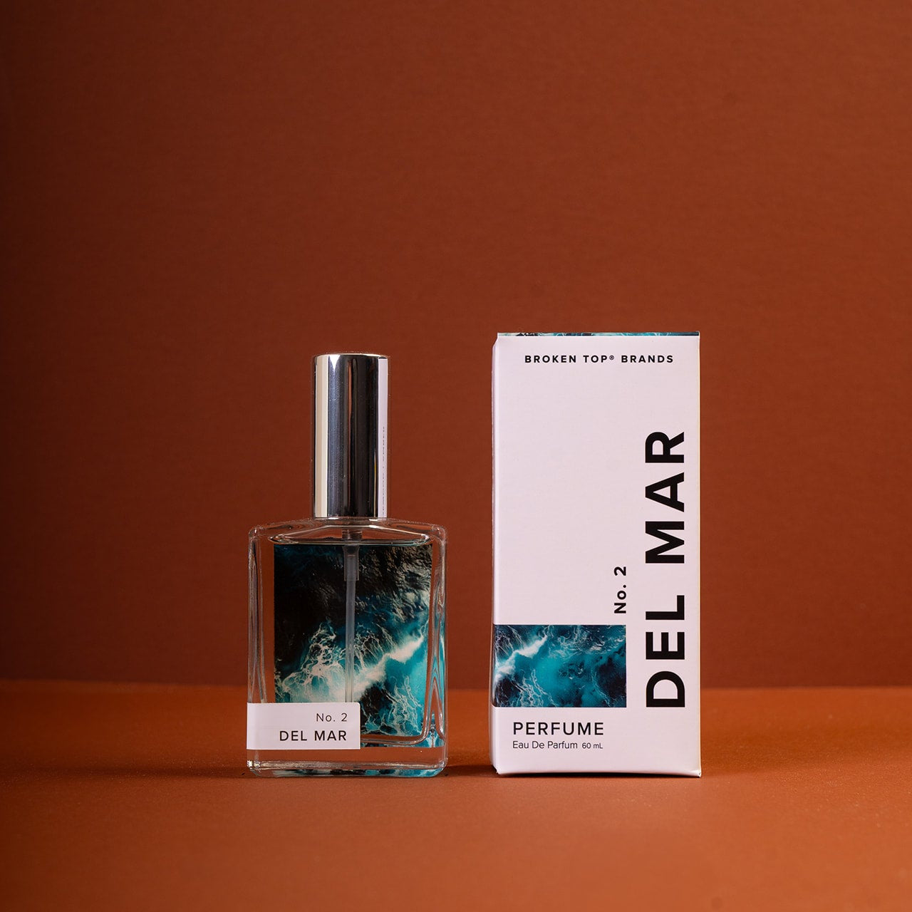 Del Mar perfume bottle and packaging on a brown background