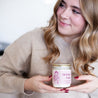 Young woman smiling, holding 9oz 'Birthday Babe' Soy Candle