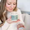 Woman smelling 9oz 'La Dolce Vita' Soy Candle with lid off