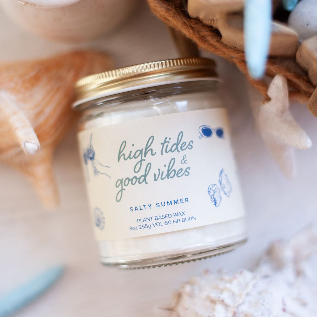 9oz 'High Tides & Good Vibes' Soy Candle on side on white table surrounded by sea shells