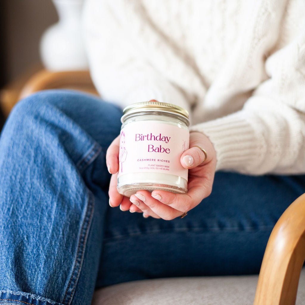 Woman holding 9oz 'Birthday Babe' Soy Candle, sitting in chair