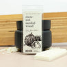 Coconut Sandalwood Wax Melts infront of black wax warmer next to coconut shavings