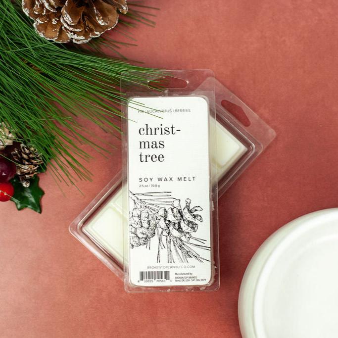 Christmas Tree 2.5oz wax melts on red table next to holiday decor