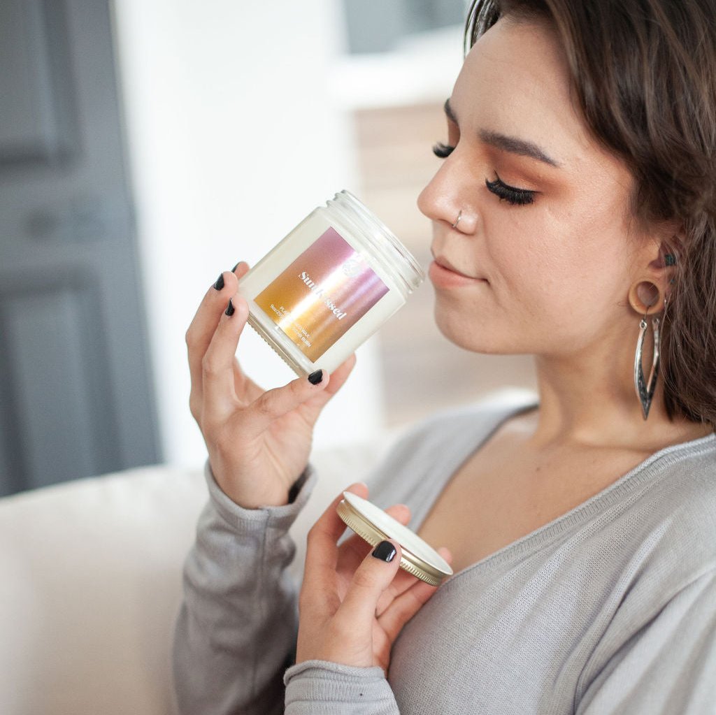 Young woman smelling 9oz 'Sun Kissed' Soy Candle