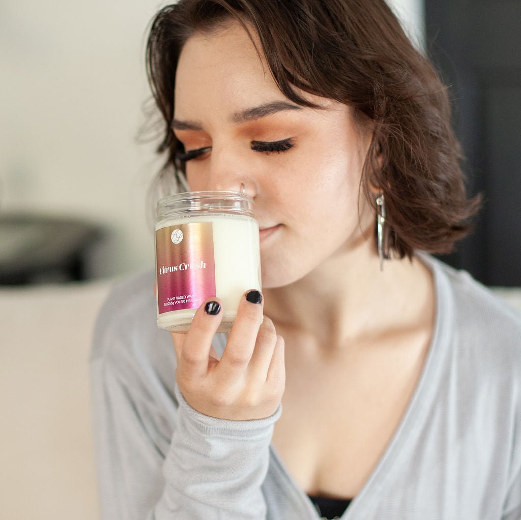 Young woman smelling 9oz 'Citrus Crush' Soy Candle