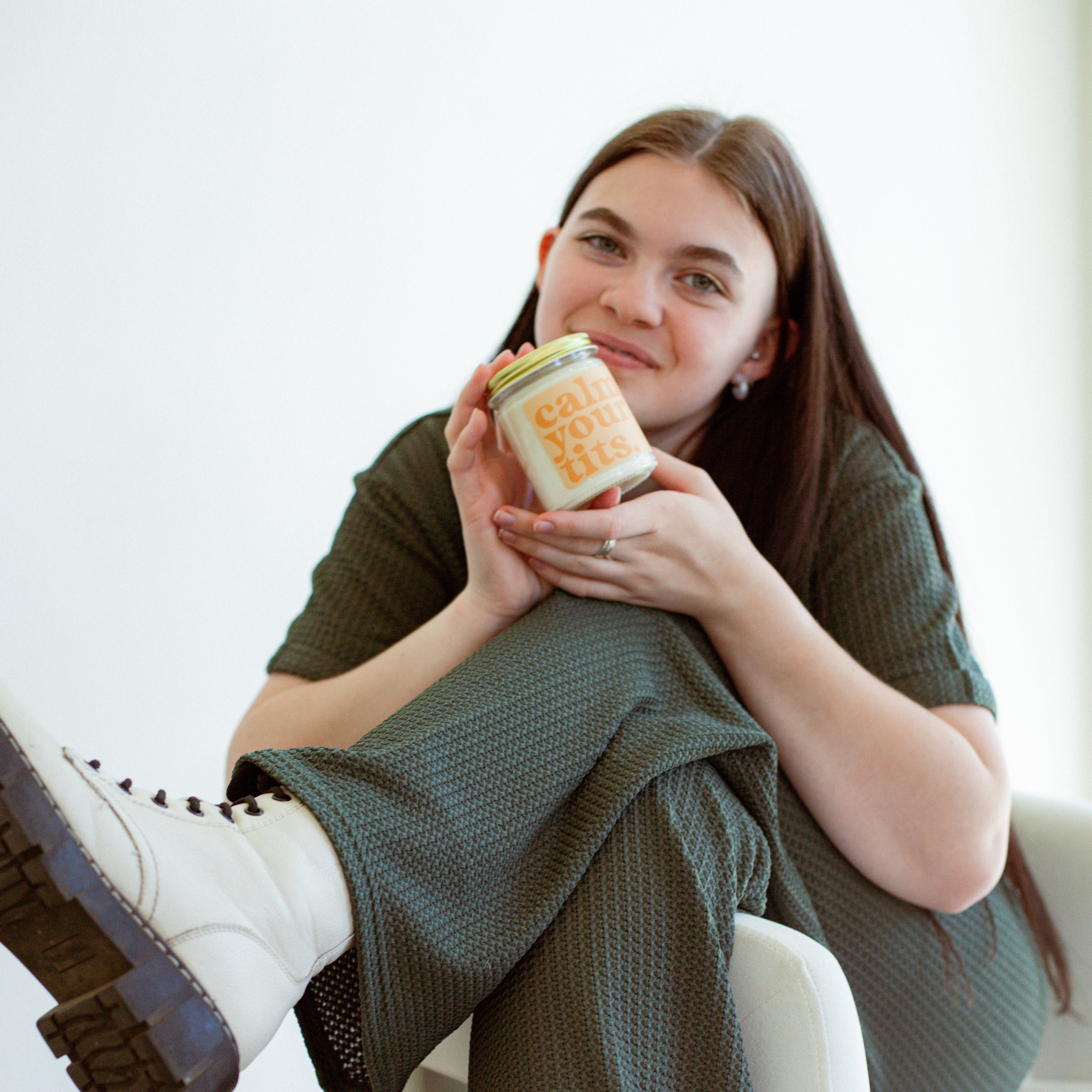 9oz 'Calm Your Tits' Soy Candle being held by a young woman. 