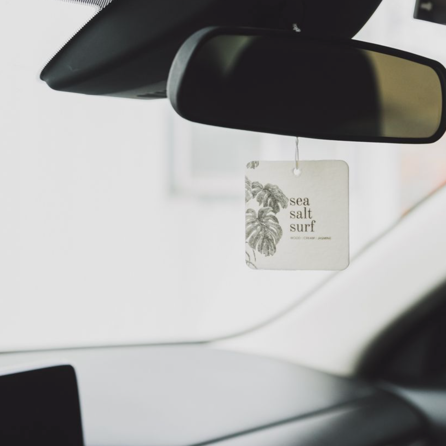 Sea Salt Surf Car Freshener hanging from a rearview mirror. 