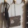 Tobacco Teak Car Freshener hanging on a hook. 