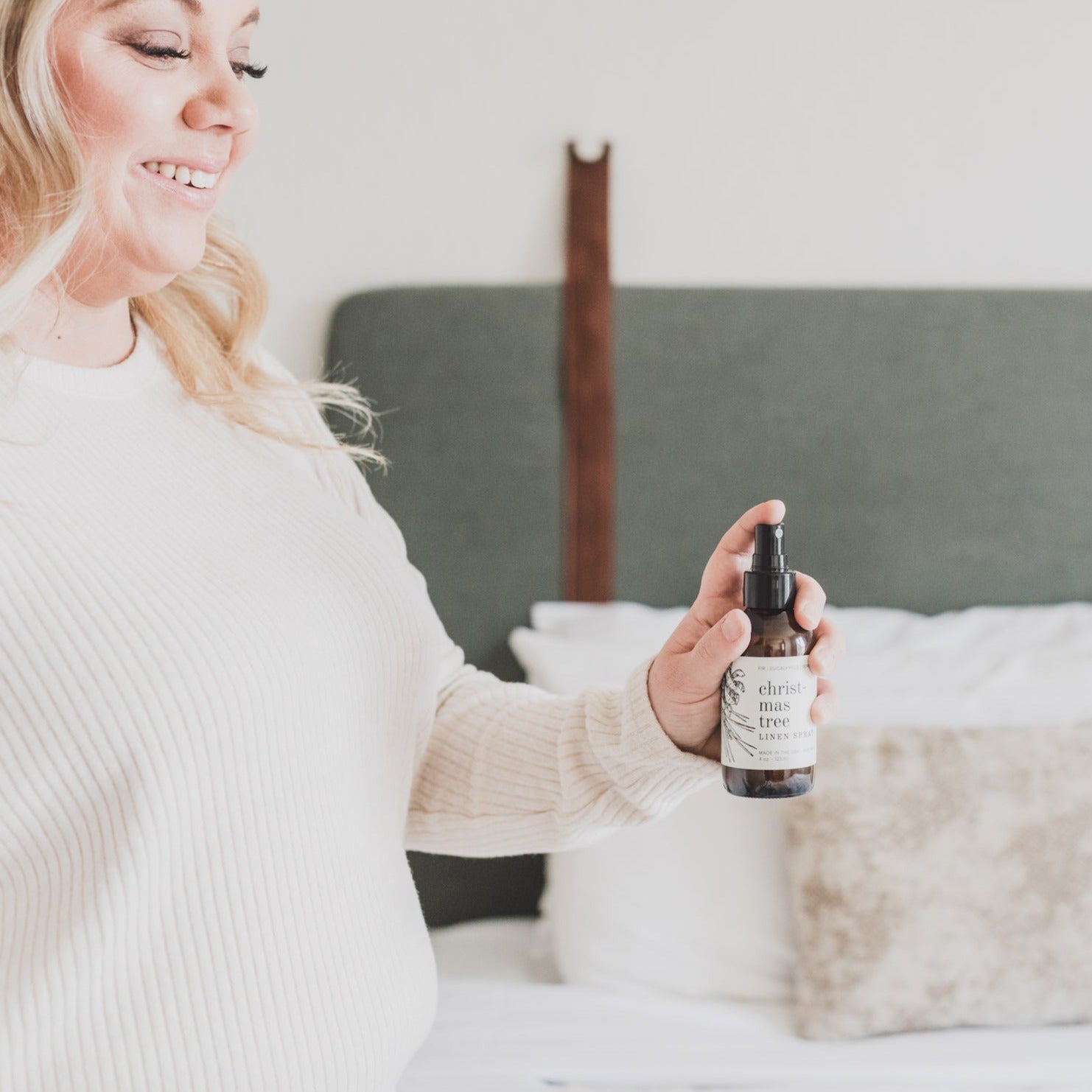 4oz Christmas Tree linen spray being sprayed by smiling women