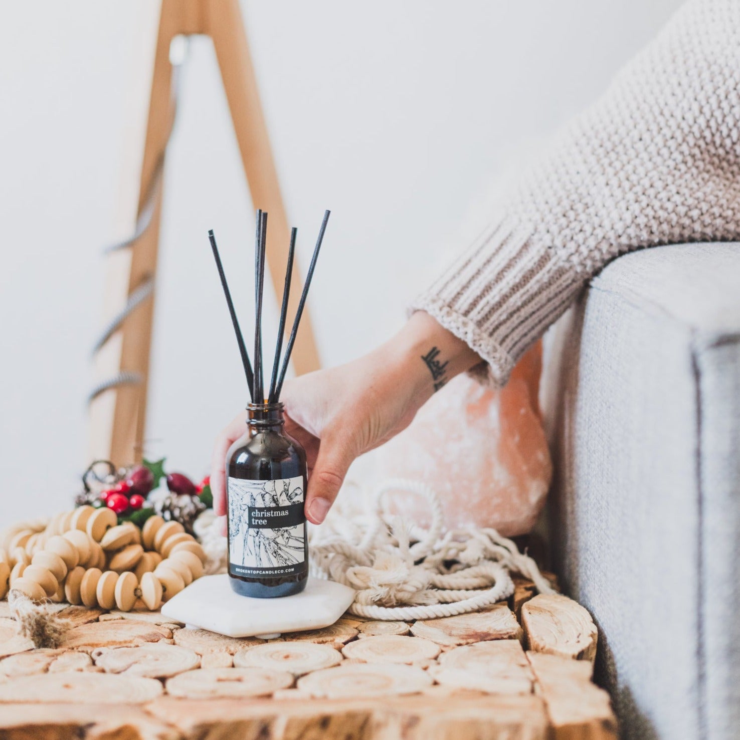 Christmas Tree Reed diffuser on coaster with women's hand