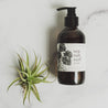 Sea Salt Surf 8oz liquid soap on marble table and green plant